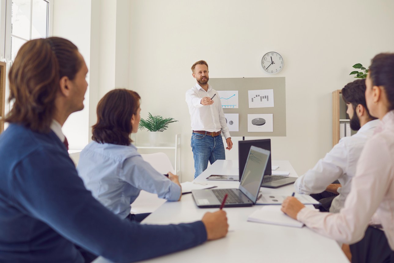 Young Marketing or Sales Department Worker Making Presentation in a Corporate Meeting